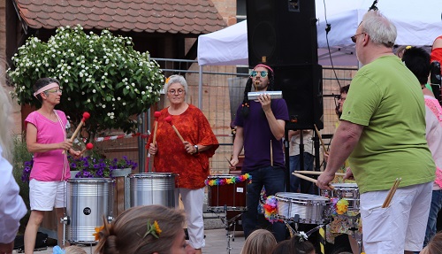 3 Erwachsene mit Lehrer und Trommeln etc., Samba spielend