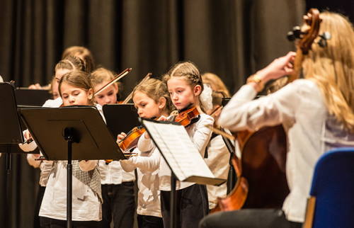 Kinder, Geige spielend und eine erwachsenenFrau am Cello