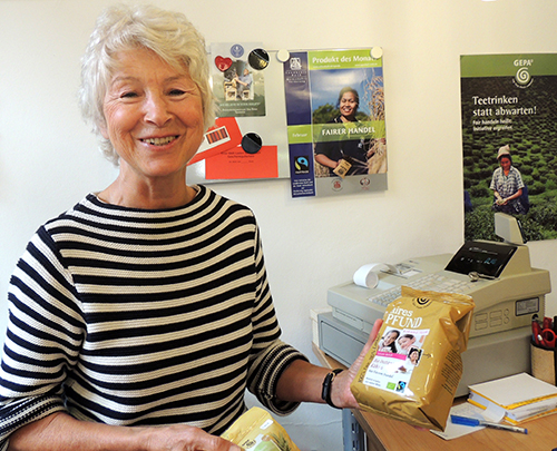Mitarbeiterin im Eine-Welt-Laden zeigt das Faire Pfund
