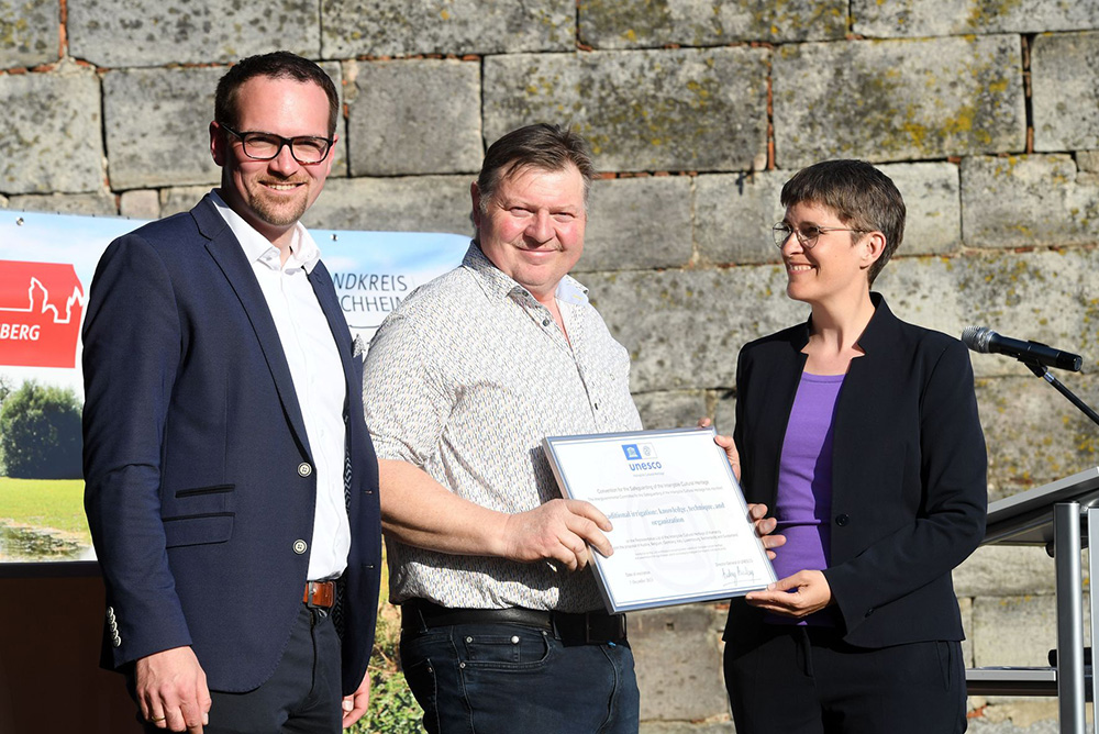 von links: Oberbürgermeister Peter Reiß, Herbert Adel und die Staatsministerin Dr. Anna Lührmann bei der Urkunden-Übergabe.