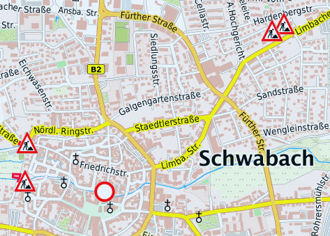 Vier Männer stehen vor einem großen Bildschirm, darauf zu sehen ist eine Karte von Schwabach, die Baustellen sind durch rote Symbole markiert.