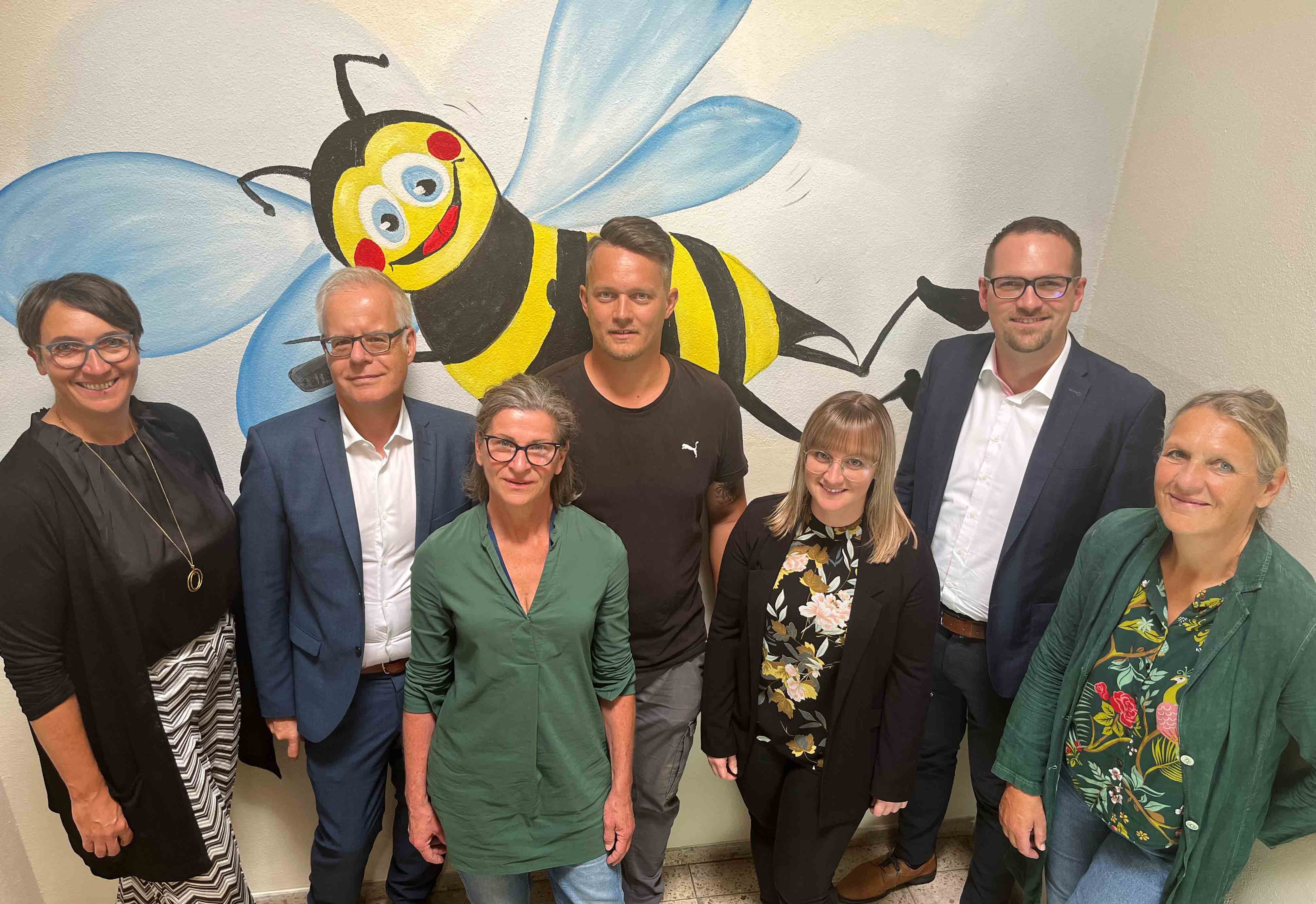 Vor dem Wandgrafitti der Kita Bienenstock trafen sich (von links) Bruni Adam (Leiterin des Jugendamts), Sozialreferent Knut Engelbrecht, Susanne Grundl (Leiterin Haus für Kinder Altstadt), Jonathan Bieber (Amt für Gebäudemanagement), Tanja Kaußler (stellvertretende Leiterin Haus für Kinder Altstadt), Oberbürgermeister Peter Reiß und Margarete Koenen (Leiterin Amt für Gebäudemanagement)