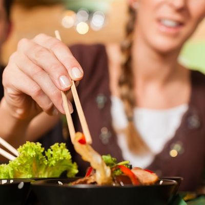 Foto Dame im Hintergrund isst mit Stäbchen
