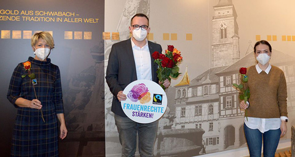 Oberbürgermeister Peter Reiß überreicht zwei Mitarbeiterinnen aus dem Rathaus eine Faire Rose.